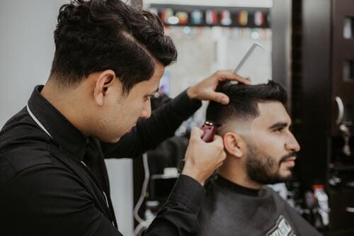 barbero cortando pelo cliente