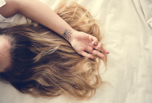 mujer en cama mostrando-pelo-peluquería quinta normal